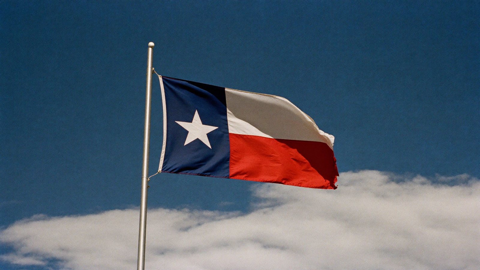 The Texas flag over a modern city skyline